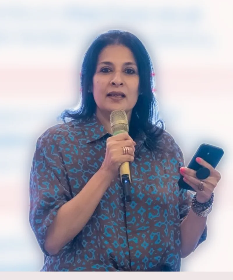 Sangeeta Krisna speaking to an audience, microphone in hand